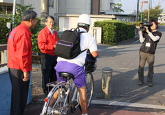 委員長Ｌ横井義彦、Ｌ横井勝己、生徒に声をかけパンフレットを渡すところを取材するクローバーＴＶスタッフ