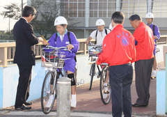 朝日を背に登校してくる生徒に啓蒙活動をするクラブ員