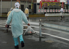 雨の中ごみを運ぶクラブ員